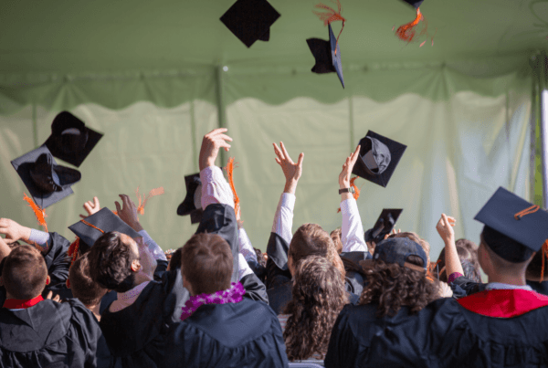 a group of people throwing graduation caps in the air Chevening Fellowship