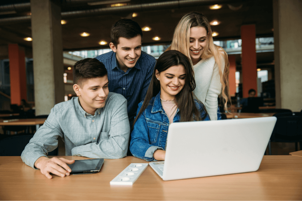 a group of people looking at a laptop