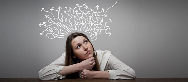 a person sitting at a table with arrows above her head
